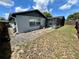 Home's backyard features a gravel area, grass, and a screened-in pool at 7719 Gaston Dr, Port Richey, FL 34668