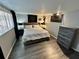 Cozy bedroom with wood-look flooring, dresser, night stands and window at 7719 Gaston Dr, Port Richey, FL 34668