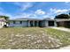 Single-story home featuring an arched entryway, screened in porch, and a quaint front yard at 7719 Gaston Dr, Port Richey, FL 34668