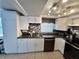Bright kitchen with white cabinetry, black countertops and stainless steel appliances at 7719 Gaston Dr, Port Richey, FL 34668