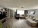 Open living room with hardwood floors, a large sectional sofa, and a gray color scheme at 7719 Gaston Dr, Port Richey, FL 34668