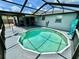 Screened in backyard featuring a round pool with a covered outdoor seating area at 7719 Gaston Dr, Port Richey, FL 34668