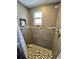 Walk-in shower with gray tile, mosaic floor, niche, and window at 7719 Gaston Dr, Port Richey, FL 34668