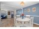 Dining area with white table set and an adjacent living area with blue couch at 8021 Wildflower Row, Hudson, FL 34667