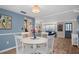 Bright dining area with a white table, wood floors and blue accent wall at 8021 Wildflower Row, Hudson, FL 34667