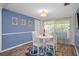 Charming dining area with a round table, white chairs, colorful rug, and natural light at 8021 Wildflower Row, Hudson, FL 34667