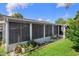 Exterior view of a screened in patio area with landscaping and lush backyard views at 8021 Wildflower Row, Hudson, FL 34667