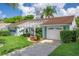 Charming single-story home featuring a well-maintained lawn and an attached one-car garage at 8021 Wildflower Row, Hudson, FL 34667
