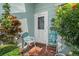 Inviting front porch with seating and vibrant landscaping, creating a warm welcome to the home at 8021 Wildflower Row, Hudson, FL 34667