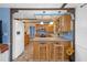 View of kitchen with breakfast bar featuring stainless appliances and wood cabinets at 8021 Wildflower Row, Hudson, FL 34667