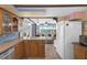 Functional kitchen layout with wooden cabinets and appliances, seamlessly connects to the living area at 8021 Wildflower Row, Hudson, FL 34667