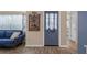 Cozy living room showcasing wood flooring, a blue front door, and comfortable seating at 8021 Wildflower Row, Hudson, FL 34667