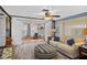 Bright living room with ceiling fan, comfortable seating, and attached sunroom at 8021 Wildflower Row, Hudson, FL 34667
