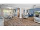 Open-concept living room features hardwood flooring, dining area and fireplace at 8021 Wildflower Row, Hudson, FL 34667