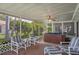 Relaxing screened patio featuring a hot tub, comfortable seating and lush backyard views at 8021 Wildflower Row, Hudson, FL 34667