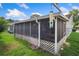 Exterior screened in patio with ceiling fan, lush backyard views, and lattice trim at 8021 Wildflower Row, Hudson, FL 34667