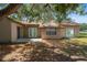 The backyard features a small patio area accessible via sliding glass doors and plenty of space for outdoor activities at 8431 Spring Hill Dr, Spring Hill, FL 34608