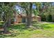 Charming home with a well-maintained lawn, mature trees, and a welcoming green front door at 8431 Spring Hill Dr, Spring Hill, FL 34608