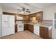 Kitchen boasts wood cabinets, white appliances, tile backsplash, and ample counter space for cooking and prep at 8431 Spring Hill Dr, Spring Hill, FL 34608