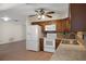 Kitchen boasts wood cabinets, white appliances, tile backsplash, and ample counter space for cooking and prep at 8431 Spring Hill Dr, Spring Hill, FL 34608