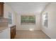 Eat-in kitchen features wood cabinets, tile backsplash, white appliances, and a window with backyard views at 8431 Spring Hill Dr, Spring Hill, FL 34608