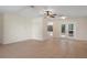 Spacious living room featuring tile floors, a ceiling fan and natural light from the doors to outside at 8431 Spring Hill Dr, Spring Hill, FL 34608