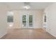 Bright living room with access to the backyard featuring tile flooring and arched doorways at 8431 Spring Hill Dr, Spring Hill, FL 34608