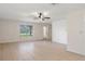 Bright and spacious living room with tile flooring, ceiling fan, and large windows for plenty of natural light at 8431 Spring Hill Dr, Spring Hill, FL 34608