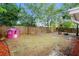 Spacious backyard featuring a wooden fence, mature trees, and a playhouse at 9111 Greenbriar Ln, Port Richey, FL 34668