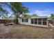 Spacious backyard featuring a covered patio and mature tree providing ample shade at 9111 Greenbriar Ln, Port Richey, FL 34668