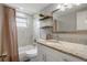 Modern bathroom featuring a granite vanity, marble tiled shower, and updated fixtures at 9111 Greenbriar Ln, Port Richey, FL 34668