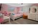 Pink themed bedroom with a cozy bed, a study table, and a dresser at 9111 Greenbriar Ln, Port Richey, FL 34668