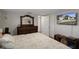 Cozy bedroom featuring a wooden dresser with mirror and a TV showing the exterior of the home at 9111 Greenbriar Ln, Port Richey, FL 34668