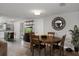 Dining area featuring a wooden table, a large round mirror, and views into the kitchen at 9111 Greenbriar Ln, Port Richey, FL 34668