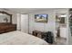Bright main bedroom with a large dresser, flat screen TV, ensuite bathroom, and neutral decor at 9111 Greenbriar Ln, Port Richey, FL 34668