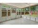 Bright sunroom featuring white paint and multiple windows overlooking a fenced in yard with playhouse at 9111 Greenbriar Ln, Port Richey, FL 34668