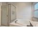 Bathroom featuring a tub and shower with glass enclosure, and a window for natural light at 9527 Southern Charm Cir, Brooksville, FL 34613