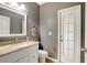 Well-lit bathroom featuring a vanity with granite countertop, toilet, and stylish door to the exterior at 9527 Southern Charm Cir, Brooksville, FL 34613
