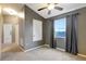 Cozy bedroom with neutral walls, ceiling fan, carpeted floors, and natural light from the window at 9527 Southern Charm Cir, Brooksville, FL 34613