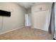 Neutral bedroom featuring plush carpeting, spacious closet, and a wall-mounted TV for ultimate comfort at 9527 Southern Charm Cir, Brooksville, FL 34613