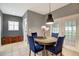 Intimate dining area with a table, blue chairs, and natural light from nearby windows and doors at 9527 Southern Charm Cir, Brooksville, FL 34613