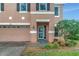 Close up of two-story home featuring front door and manicured front lawn at 9527 Southern Charm Cir, Brooksville, FL 34613