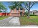 Two-story home featuring a two-car garage, well-maintained lawn and exterior, and mature shade tree at 9527 Southern Charm Cir, Brooksville, FL 34613
