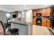 Spacious kitchen with a bar, wood cabinets, black appliances, and a dining area at 9527 Southern Charm Cir, Brooksville, FL 34613