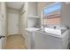 Bright laundry room features tile flooring, washer, dryer, and a window for natural light at 9527 Southern Charm Cir, Brooksville, FL 34613