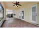 Screened-in patio features tiled flooring, outdoor seating, and access doors to the backyard at 9527 Southern Charm Cir, Brooksville, FL 34613