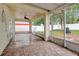 Spacious tiled patio featuring a ceiling fan, string lights, and backyard views with a screened enclosure at 9527 Southern Charm Cir, Brooksville, FL 34613