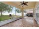 A screened patio with tile floors, fan, string lights, and an inviting egg chair for outdoor relaxation at 9527 Southern Charm Cir, Brooksville, FL 34613