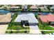 Aerial view of the home showcasing its well-manicured lawn and surrounding neighborhood on the water at 9810 Compass Point Way, Tampa, FL 33615