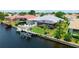 Aerial view of backyard featuring a boat lift on a waterfront canal, a screen enclosed pool, and back deck at 9810 Compass Point Way, Tampa, FL 33615